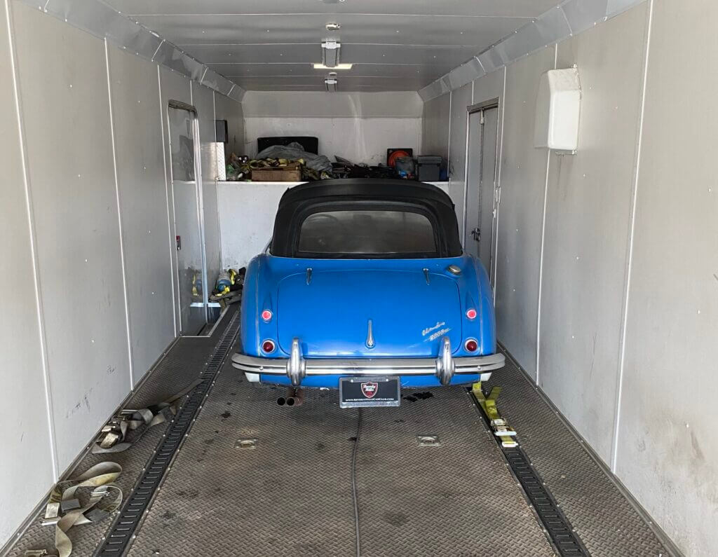 An electric blue 1960s Austin-Healey loaded inside a two-car covered transport trailer. If you're looking for a reliable enclosed car shipping company, you have come to the right place! Considering some key factors - reputation, experience, insurance and quotation-can make all the difference in ensuring the right enclosed auto transport company completes the job without issue.